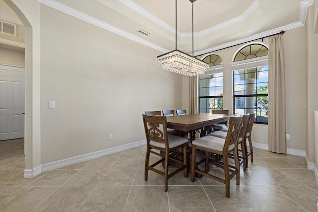 dining room featuring ornamental molding, a chandelier, a raised ceiling, and light tile patterned floors