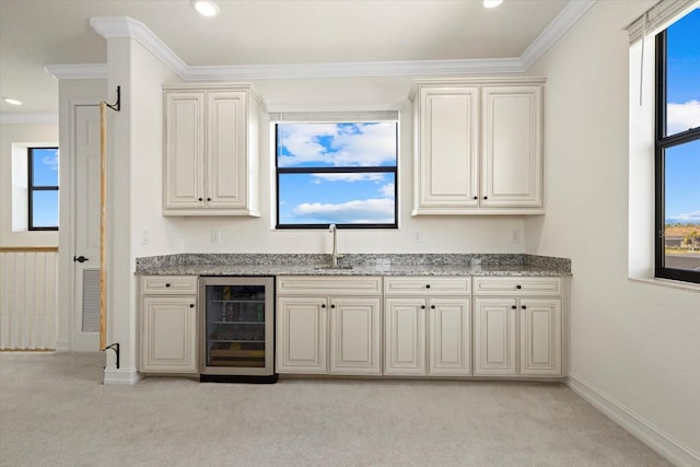 bar featuring ornamental molding, wine cooler, cream cabinets, and light colored carpet