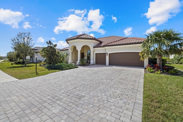 mediterranean / spanish-style home with a front yard and a garage