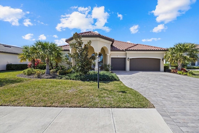 mediterranean / spanish home featuring a garage and a front lawn