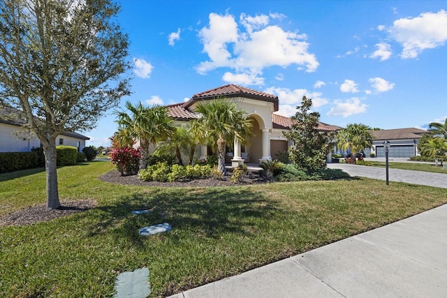 mediterranean / spanish home featuring a front lawn and a garage