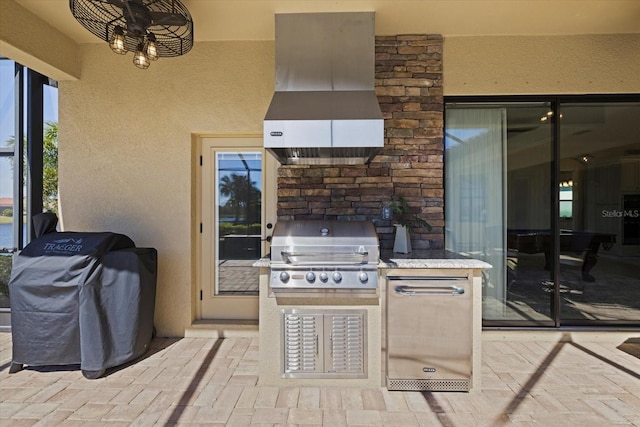 view of patio with exterior kitchen and a grill