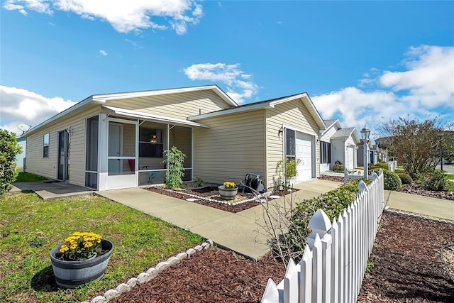 view of front of house featuring a sunroom and a garage