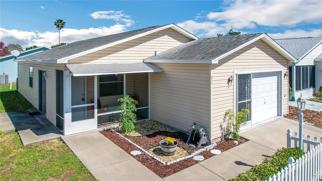 view of front of house with a sunroom and central AC