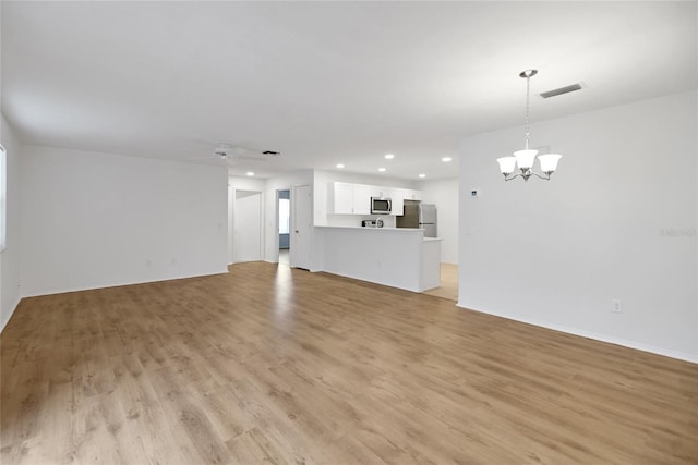 unfurnished living room with light hardwood / wood-style flooring and ceiling fan with notable chandelier