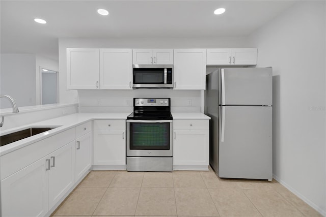 kitchen with appliances with stainless steel finishes, white cabinets, and sink