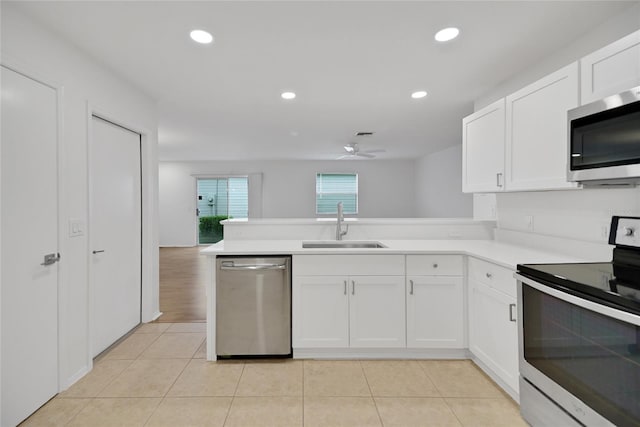 kitchen with kitchen peninsula, ceiling fan, appliances with stainless steel finishes, white cabinetry, and sink