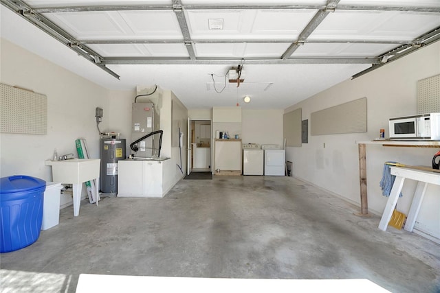 garage featuring washing machine and dryer, sink, a garage door opener, heating unit, and electric water heater