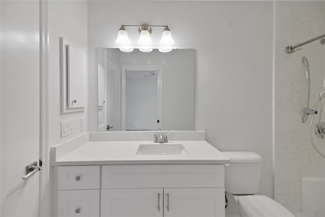 bathroom featuring toilet, vanity, and a tile shower