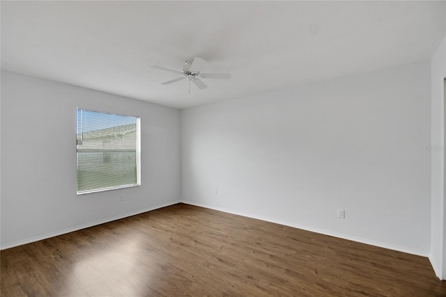 empty room featuring dark wood-type flooring and ceiling fan