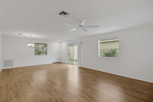 empty room featuring light hardwood / wood-style flooring and ceiling fan with notable chandelier