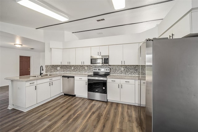 kitchen featuring appliances with stainless steel finishes, sink, kitchen peninsula, and white cabinets