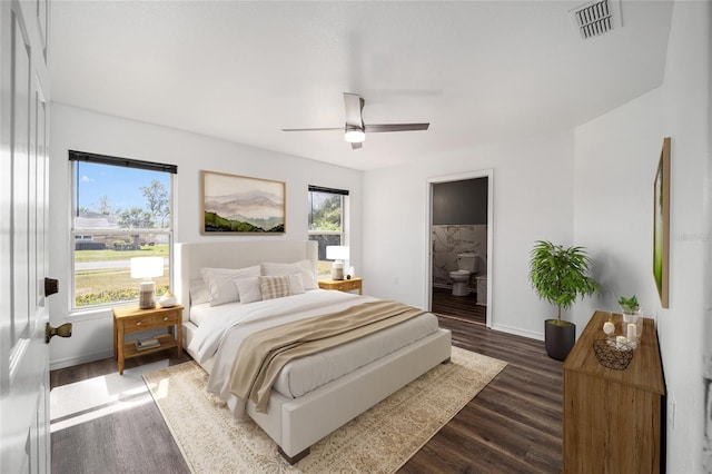 bedroom featuring dark hardwood / wood-style flooring, ensuite bathroom, and ceiling fan