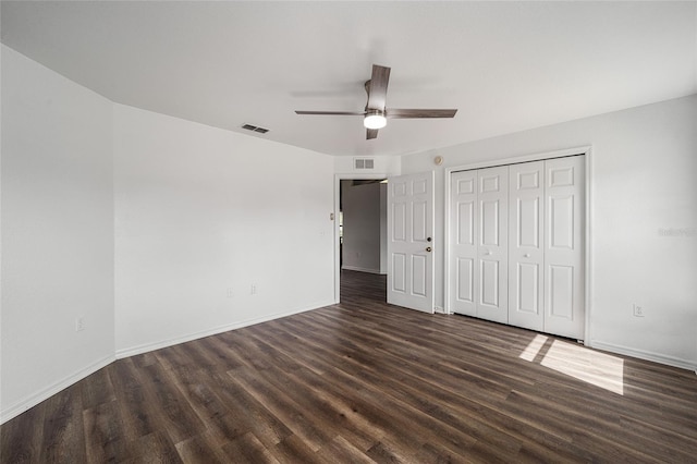 unfurnished bedroom with dark hardwood / wood-style floors, a closet, and ceiling fan