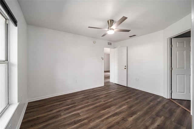 unfurnished bedroom featuring dark wood-type flooring, multiple windows, and ceiling fan