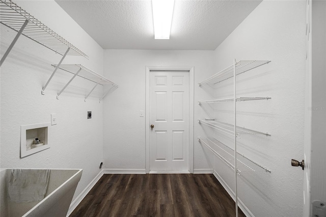 clothes washing area with hookup for an electric dryer, a textured ceiling, hookup for a washing machine, and dark hardwood / wood-style flooring