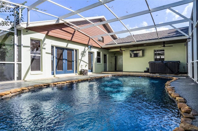 back of property with glass enclosure, french doors, a patio, and ceiling fan