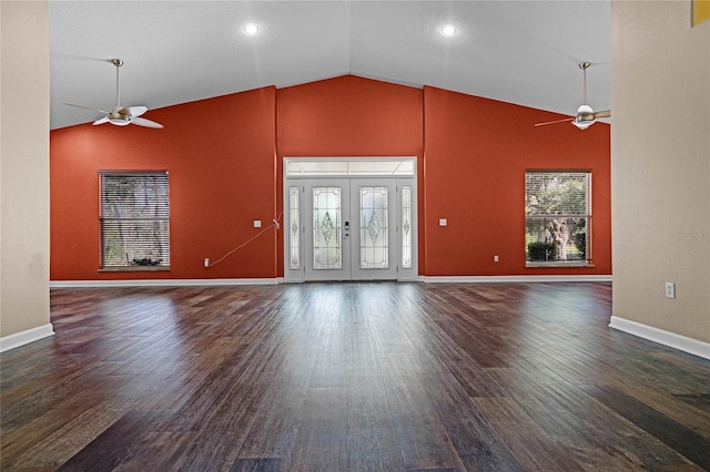 unfurnished living room with dark wood-type flooring, ceiling fan, high vaulted ceiling, and french doors