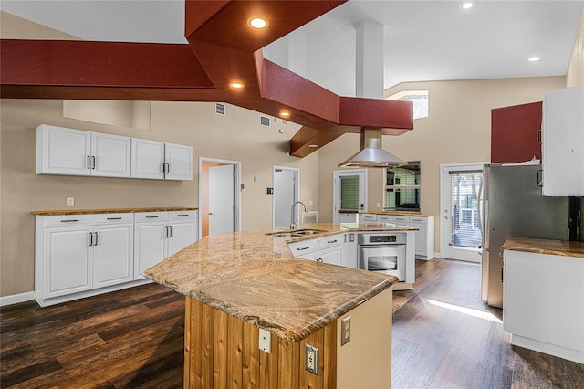 kitchen featuring white cabinetry, appliances with stainless steel finishes, a large island, dark hardwood / wood-style flooring, and sink