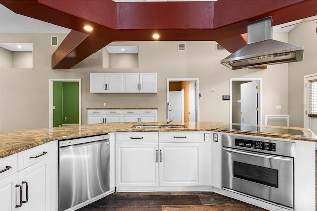 kitchen with stainless steel appliances, dark wood-type flooring, white cabinets, sink, and range hood