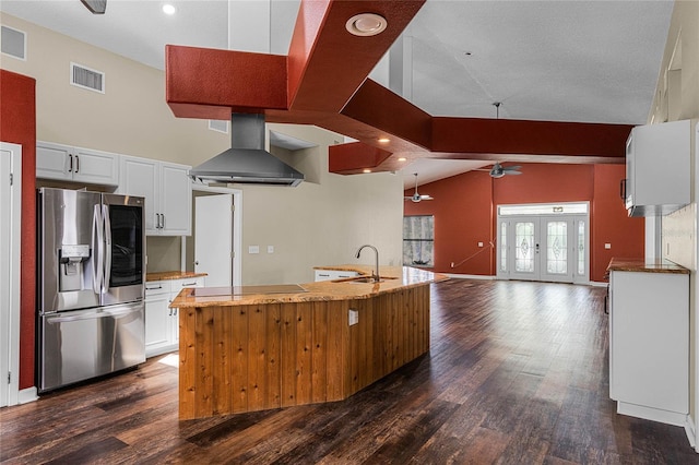 kitchen featuring white cabinets, stainless steel refrigerator with ice dispenser, ventilation hood, and vaulted ceiling