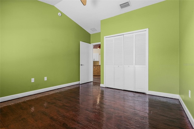 unfurnished bedroom featuring dark hardwood / wood-style flooring, a closet, vaulted ceiling, and ceiling fan