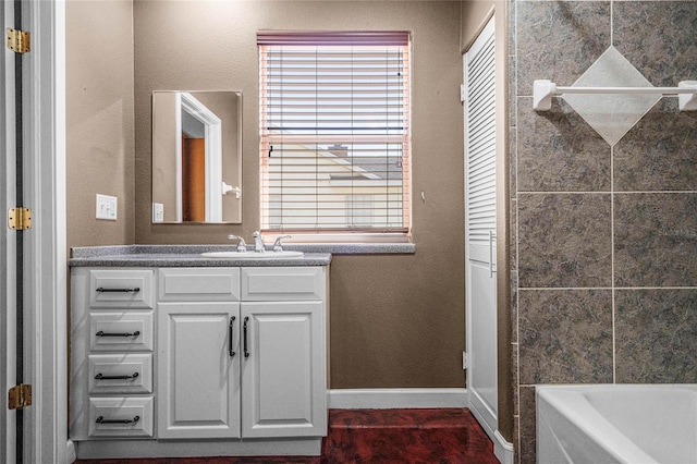 bathroom with a bath, tile patterned flooring, and vanity