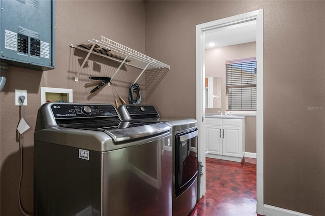 laundry room featuring washing machine and dryer, electric panel, and sink