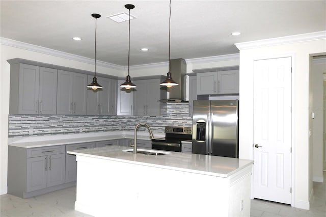 kitchen with an island with sink, sink, hanging light fixtures, stainless steel appliances, and wall chimney exhaust hood