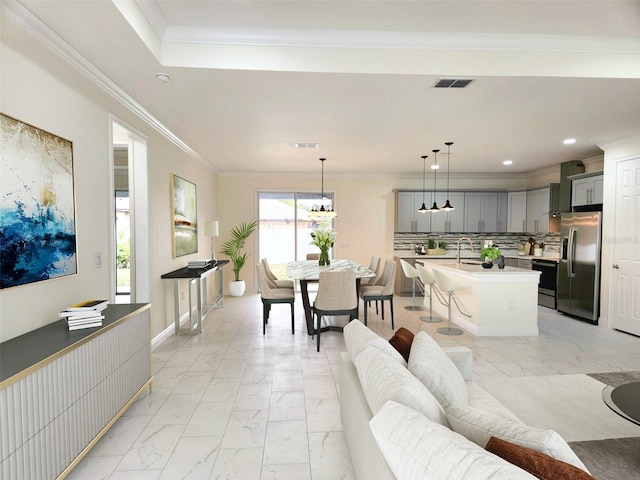 living room featuring ornamental molding and sink