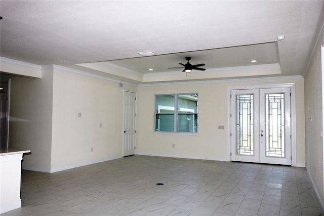 foyer entrance with a raised ceiling, crown molding, and french doors