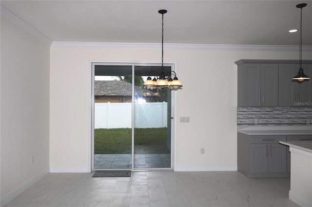 unfurnished dining area featuring ornamental molding and a chandelier