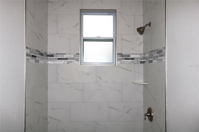 bathroom with a wealth of natural light and a tile shower