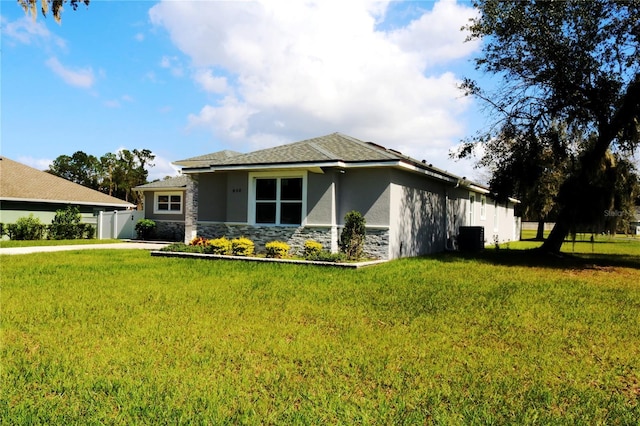 view of front facade featuring central AC and a front lawn