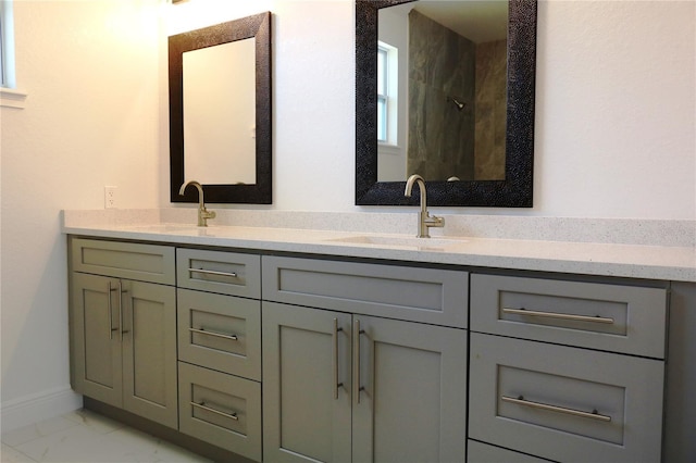 full bath featuring marble finish floor, double vanity, a shower, and a sink