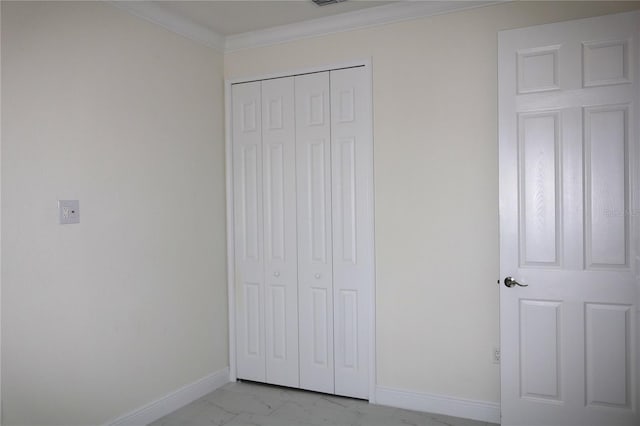 unfurnished bedroom featuring marble finish floor, a closet, visible vents, ornamental molding, and baseboards