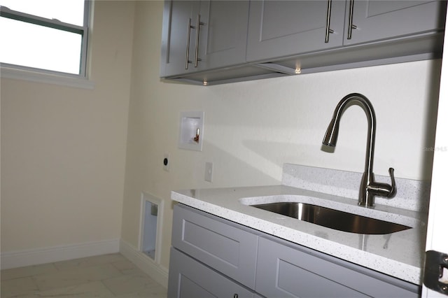 clothes washing area featuring cabinet space, a sink, hookup for a washing machine, marble finish floor, and electric dryer hookup