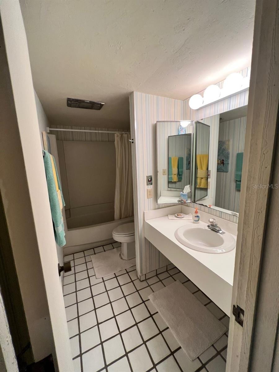 full bathroom featuring sink, tile patterned flooring, shower / bath combo, and toilet