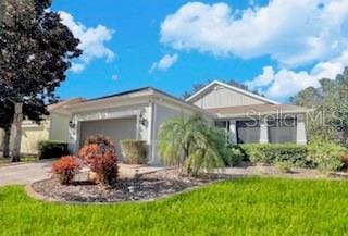 ranch-style home with a garage and a front lawn