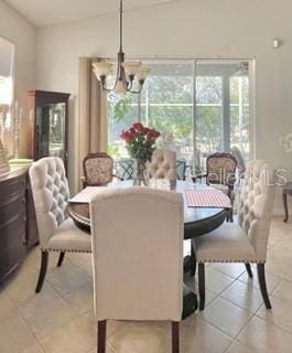 dining space featuring light tile patterned floors and a chandelier