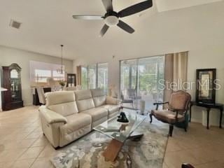 living room with ceiling fan, light tile patterned floors, and lofted ceiling