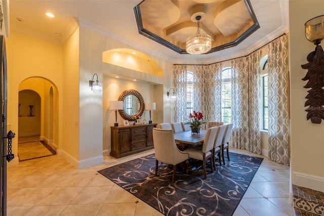 dining space with a raised ceiling, ornamental molding, and light tile patterned floors