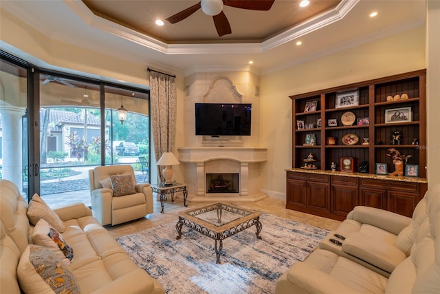 living room with ceiling fan, light tile patterned floors, crown molding, and a tray ceiling