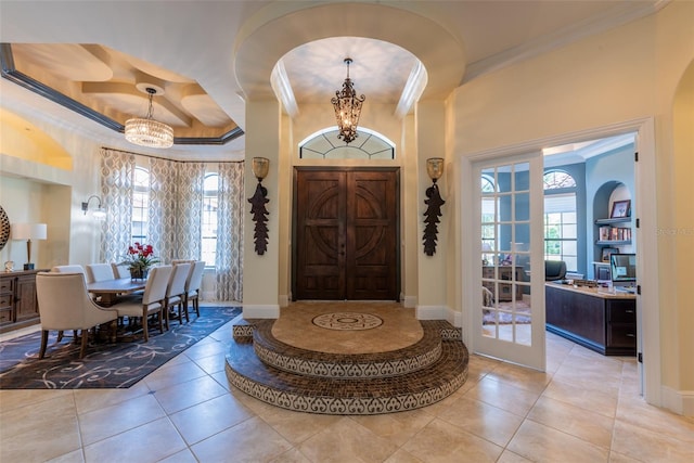 foyer entrance featuring light tile patterned floors, a wealth of natural light, and an inviting chandelier