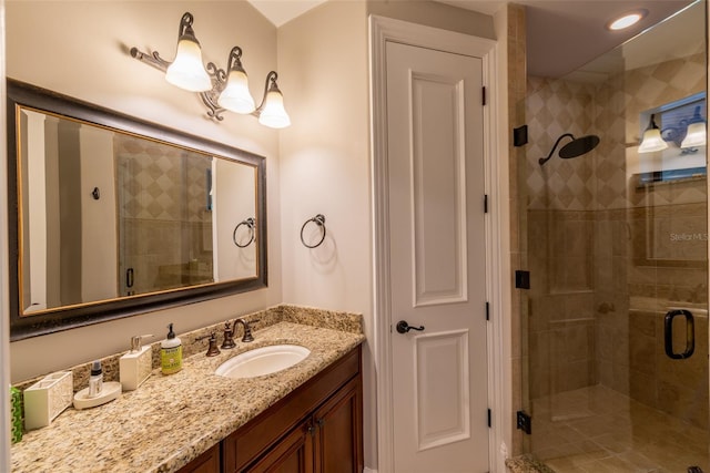 bathroom featuring vanity and a shower with door