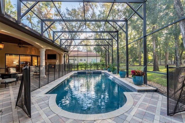 view of swimming pool featuring an in ground hot tub, glass enclosure, and a patio area