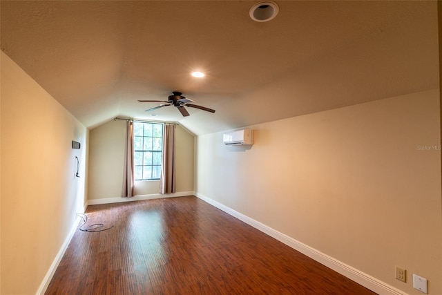 bonus room featuring a wall mounted air conditioner, ceiling fan, hardwood / wood-style flooring, and vaulted ceiling