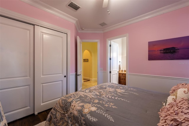 bedroom with ceiling fan, wood-type flooring, ornamental molding, and a closet