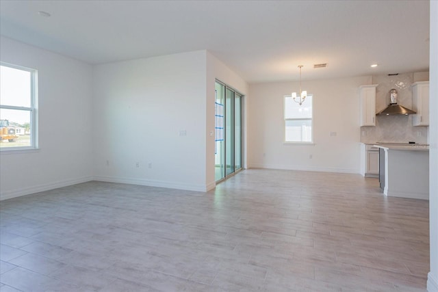 unfurnished living room with a chandelier