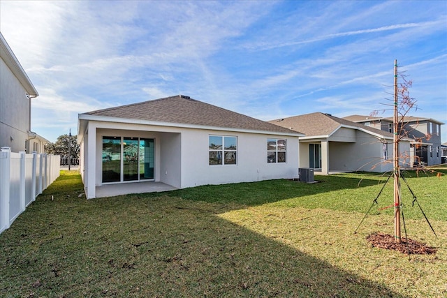 back of property with a yard and central AC unit